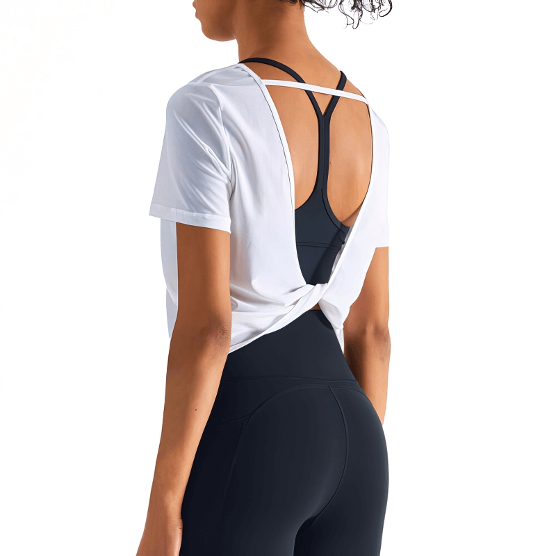 Woman wearing stylish quick-drying white open back sports T-shirt, perfect for workouts, showing breathable nylon fabric and solid design.
